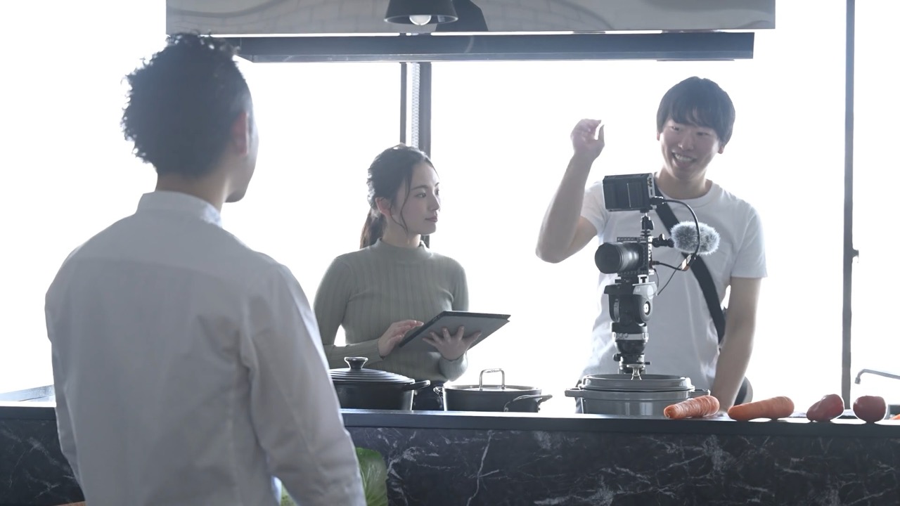 撮影現場で出演者とスタッフが打ち合わせる様子